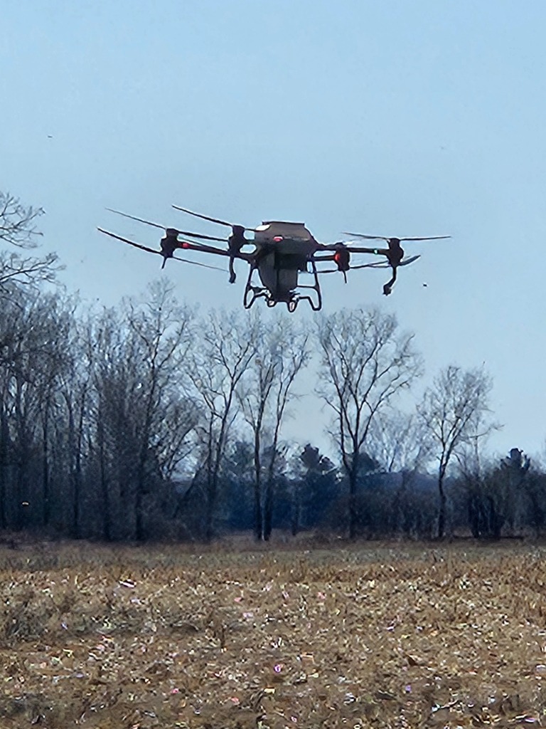 Agricultural spraying drone flying low over a Michigan field